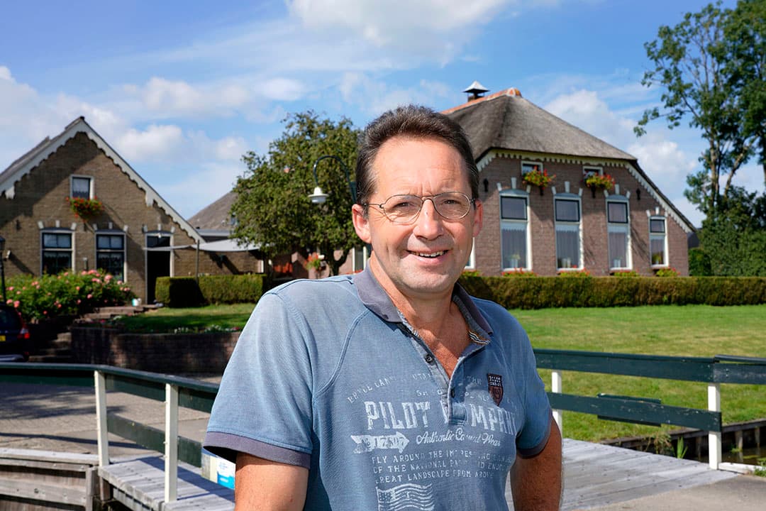 Melkveehouder Wim van Ittersum (55) voor zijn boerderij. Hij zit in maatschap met z n vrouw en één van z n vier zonen. - Foto: Ruud Ploeg