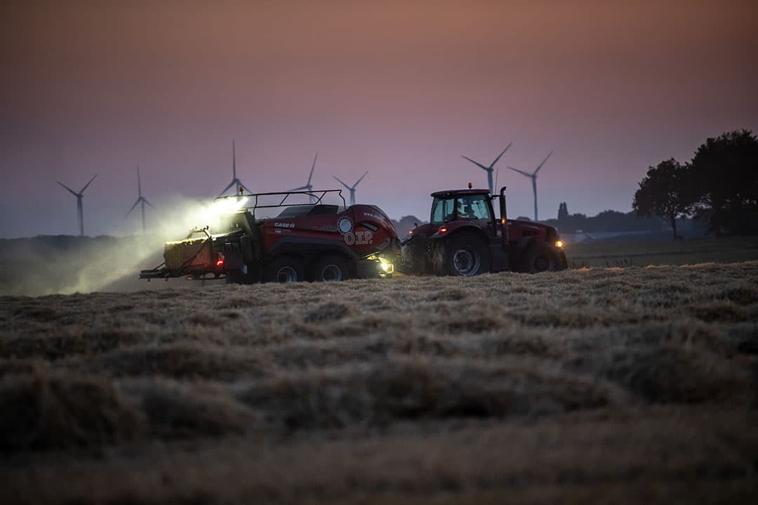 Ook in de nacht gaat het werk gewoon door. Het is dan ook nog eens een stukje koeler. Fouragehandelaar OTP uit Echten (Dr.) is bezig met het persen van stro met een nieuwe Case-balenpers. Foto: Michel Velderman