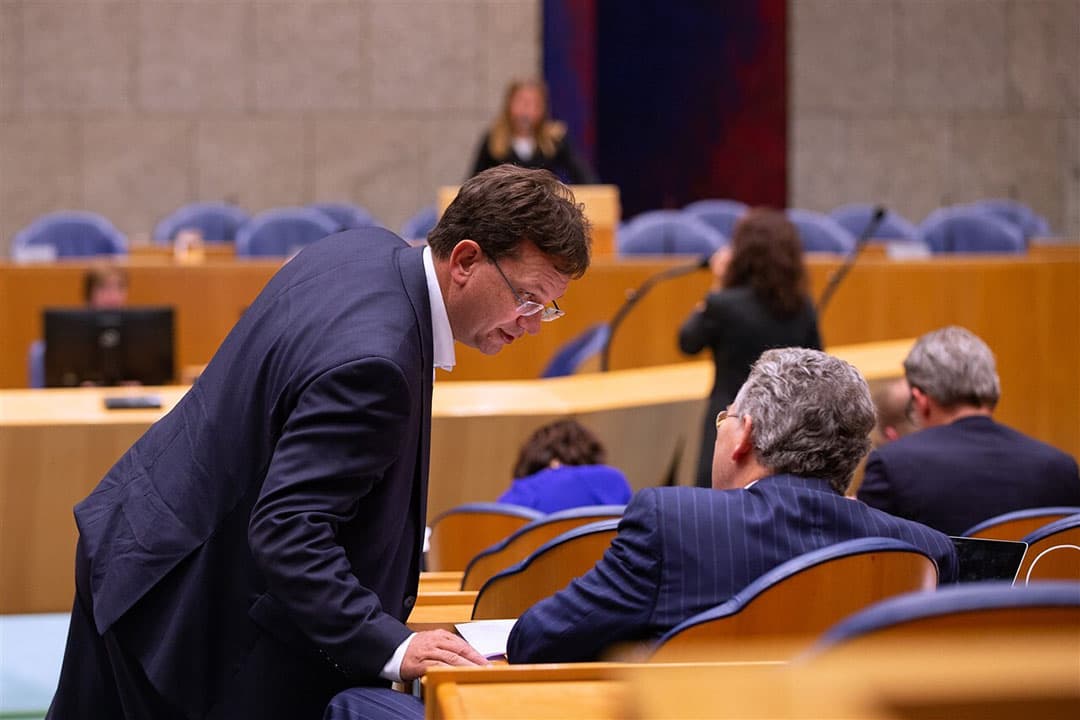 Kamerladen Jaco Geurts (CDA, links op de foto) en Roelof Bisschop (SGP, rechts) overleggen in de Tweede Kamer (archieffoto) tijdens een debat met landbouwminister Schouten. Verschillende politieke partijen in de Tweede Kamer hebben bedenkingen bij de nieuwe feiten over de voermaatregel, die donderdag 30 juli bekend zijn geworden. -  Foto: ANP