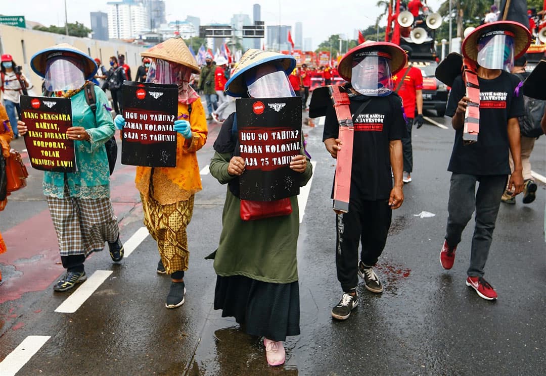 Zo ziet een demonstratie van boeren er uit in Indonesië. Geen trekkers, maar te voet met borden. Vanwege de coronaregels dragen de boeren een gelaatsmasker. - Foto: Reuters