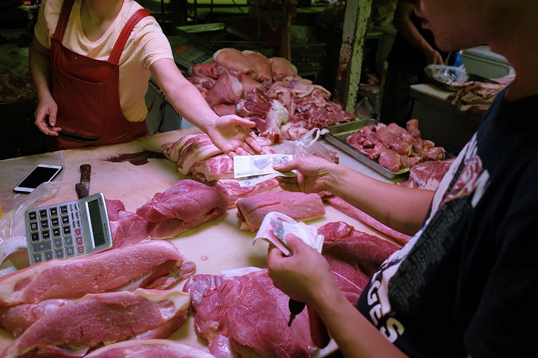 Verkoop van varkensvlees op een markt in Beijing. China blijft een hoofdrol spelen op de mondiale varkensvleesmarkt. Foto: ANP