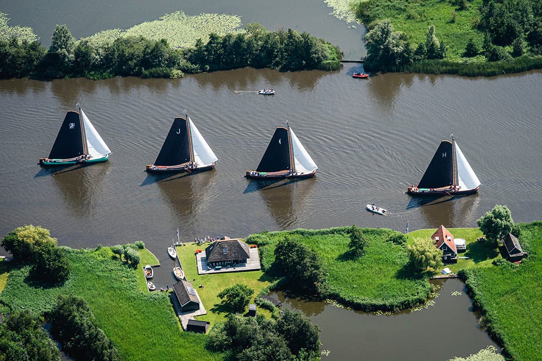 Friese platbodems op de meren van Friesland. Door de waterstand te verhogen op de Friese boezem is er meer water voor de polders beschikbaar. - Foto: ANP