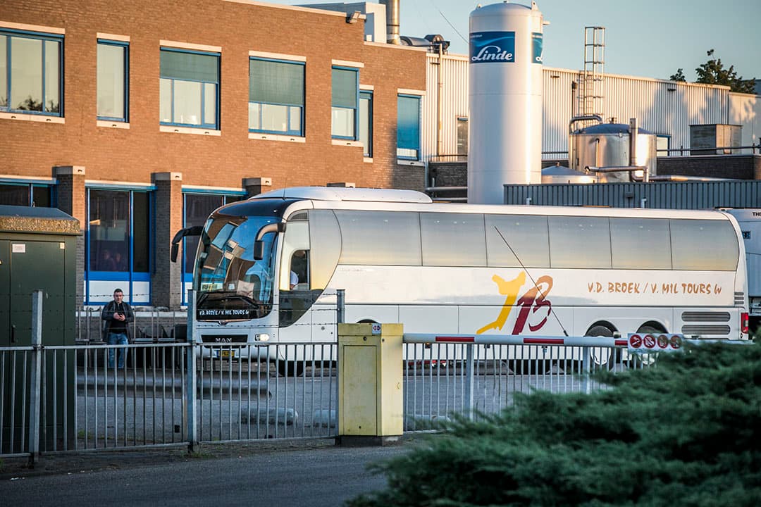 Een touringcar arriveert bij slachthuis van Vion. Vion zet touringcars in om medewerkers naar het werk te brengen. Het dragen van mondkapjes in de bussen is verplicht. - Foto: ANP