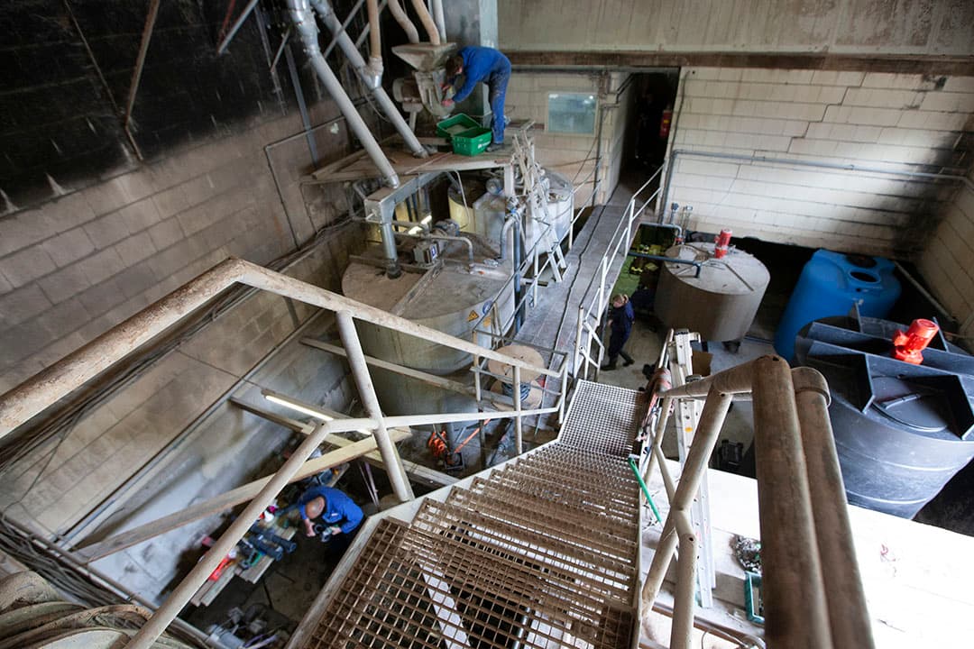In de voerkeuken wordt hard gewerkt aan verbeteringen van de bestaande brijvoerinstallatie. De monteur staat bij de filterkast van de hamermolen. - Foto: Hans Banus