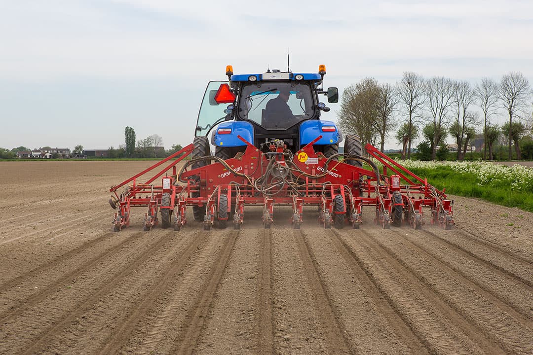 407859 Pieter-Jan Visser zaait cichorei op een veld in Nieuw-Vossemeer