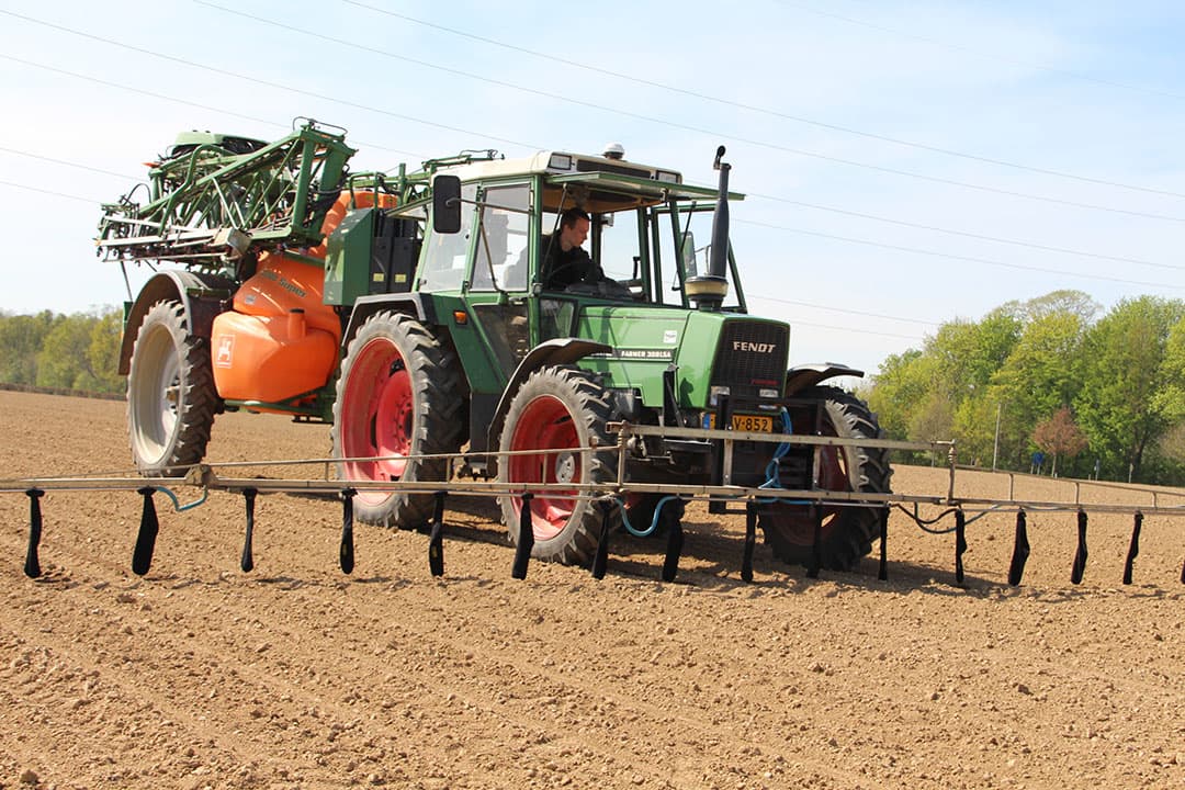 Een slang brengt het water uit de tank naar de spuitboom, waar het vervolgens over 18 rijen via de sokken wordt verdeeld. - Foto: Guus Queisen