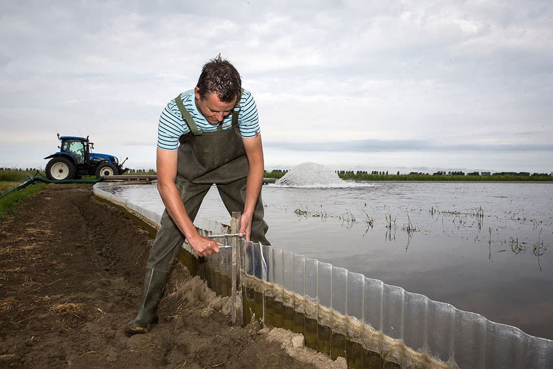 Akkerbouwer Levine Jacobs in Den Bommel (Z.-H.) past inundatie toe tegen aaltjes. Hij zorgt voor versteviging van de schotten om het water op het perceel te houden. - Foto: Peter Roek