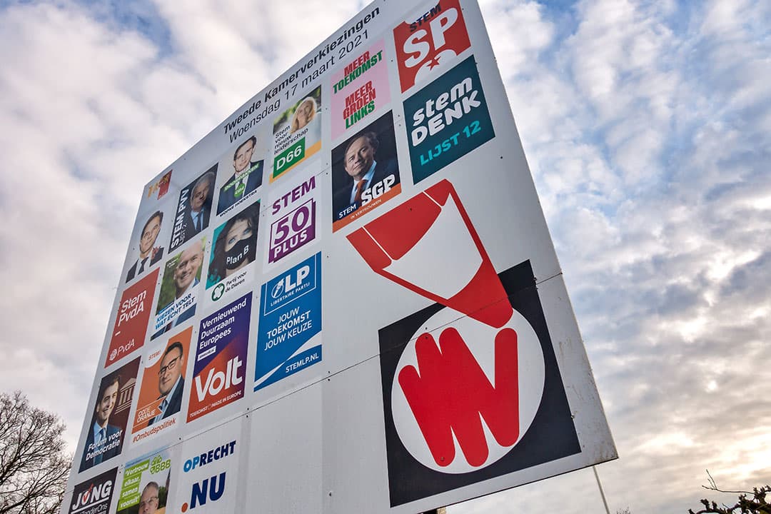 Verkiezingsbord met posters van politieke partijen die deelnemen aan de Tweede Kamer verkiezingen van 17 maart. PBL analyseerde de verkiezingsprogramma's. Foto: ANP