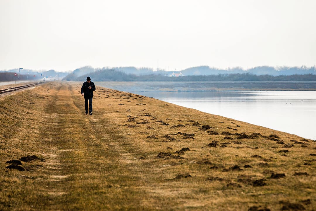 Wandelaar bij de Brouwersdam bij het Grevelingenmeer. - Foto: ANP
