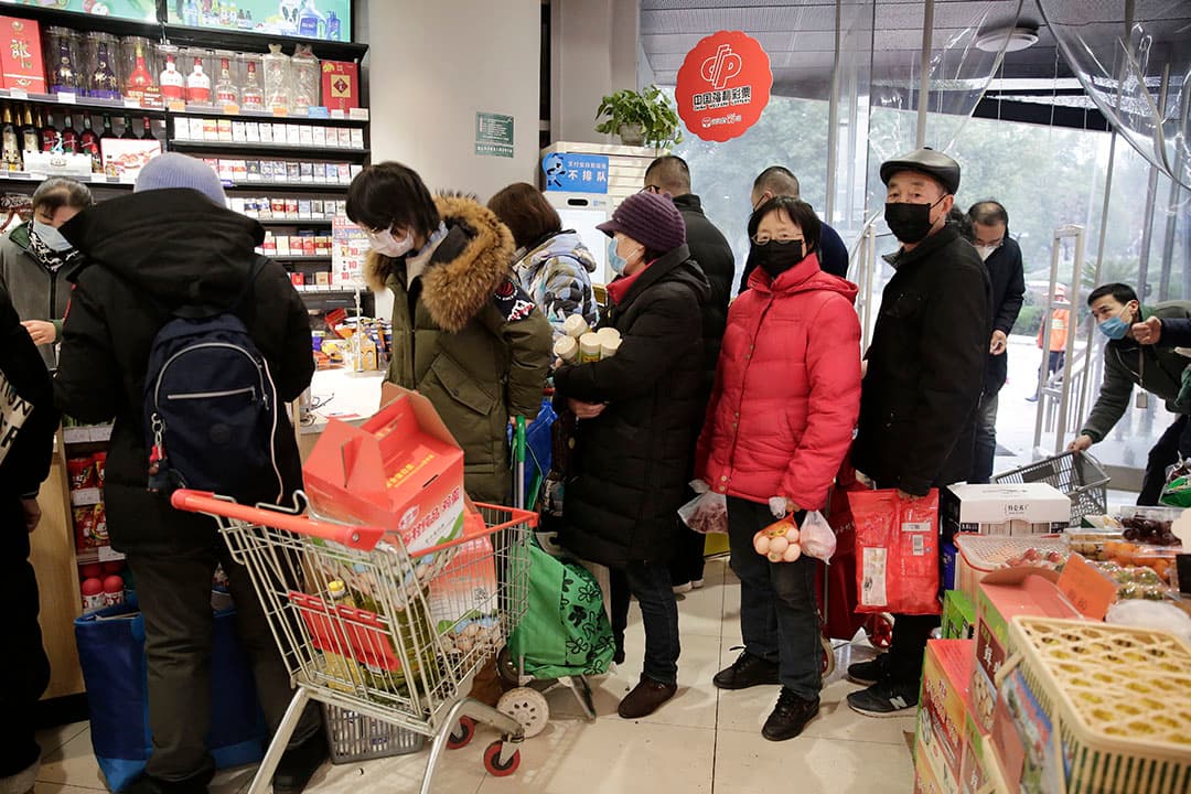 De uitbraak van het coronavirus leidt tot lange rijen in een supermarkt in de Chinese stad Wuhan. - Foto: ANP