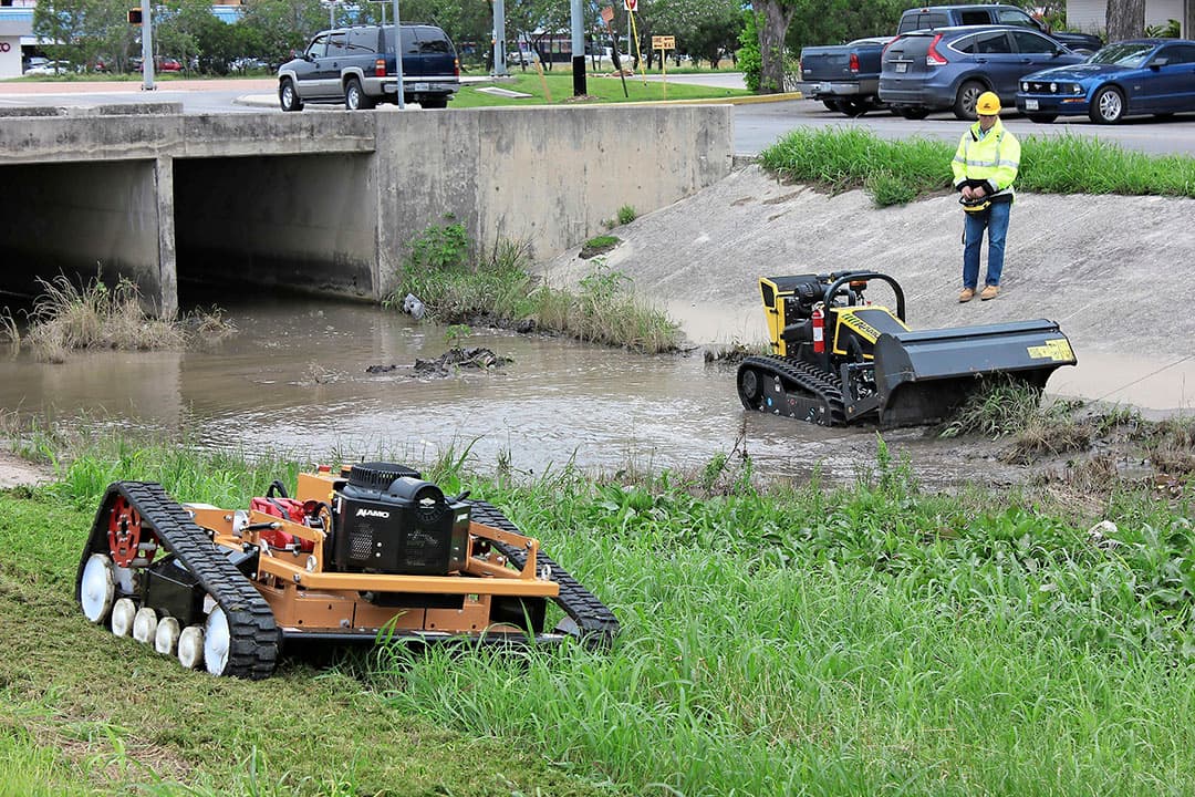 Deze Alamo Ridgerunner (voorgrond) is met tracks en een laag zwaartepunt geschikt voor drassige taluds. Moet het onderhoud vanaf het water, dan zijn daar de producten van DPC-dochter Conver. - Foto: Alamo