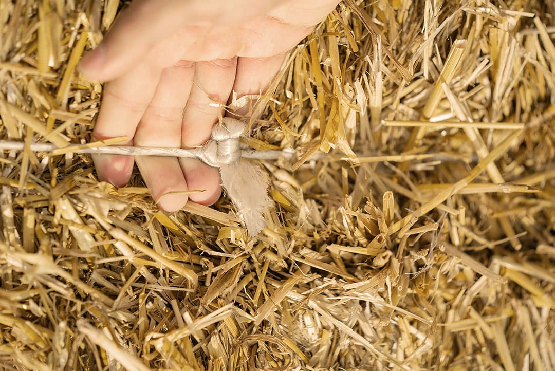 Een lusknoop is herkenbaar aan de lus (bovenin, tussen de pink en ringvinger). Volgens de leverancier moet deze knoop ook behoorlijk veel sterker zijn. Ze kan tot 30% meer kracht hebben voordat de touwen breken. - Foto: CNHi