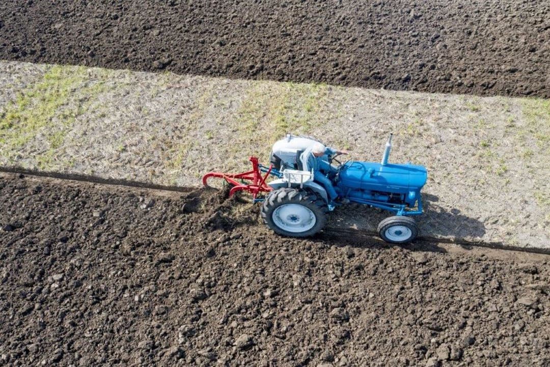Een Ford Super Dexta voor een getrokken rondgaande tweeschaar. Deze kan vanaf de trekker in diepte en breedte versteld worden. Om te meten, moet je van de trekker af.
