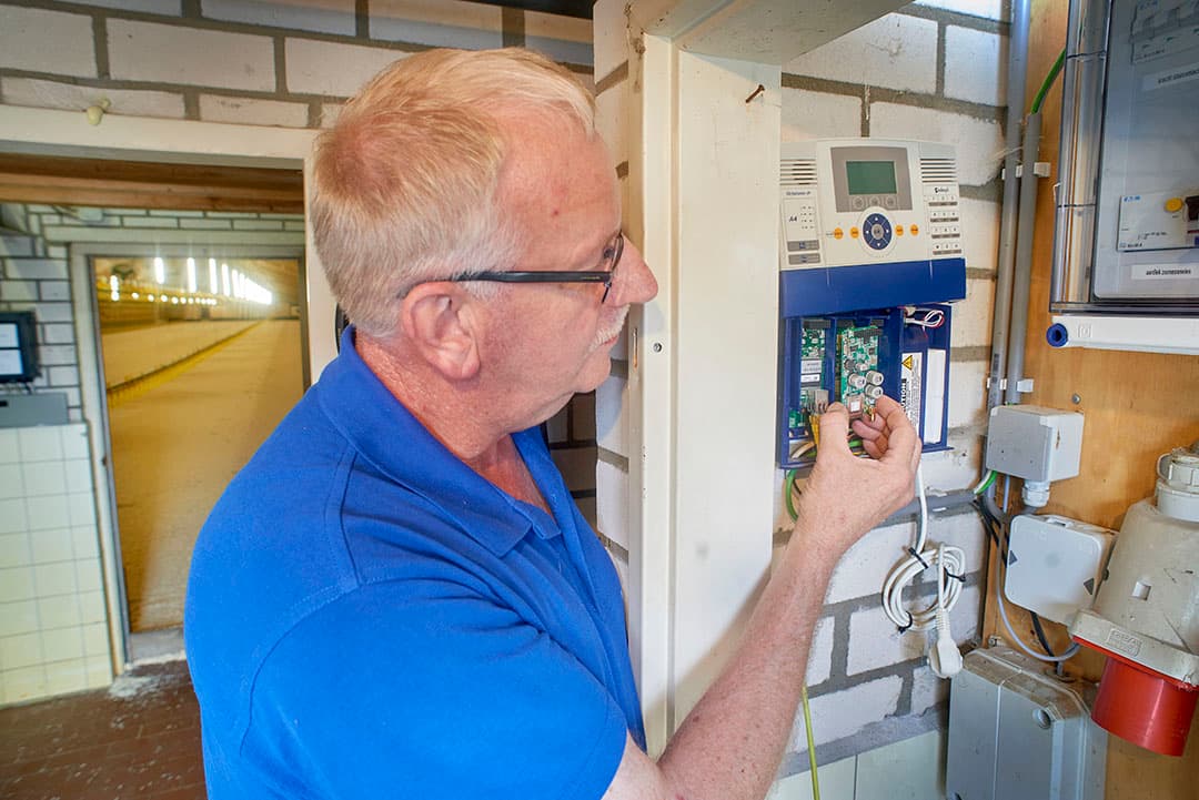 Een monteur van Boon Agrosystems plaatst een gsm-kaart in een bestaand stalalarm. Op dit bedrijf werd gebruik gemaakt van ISDN voor het uitbellen van alarmen. - Foto: Van Assendelft Fotografie