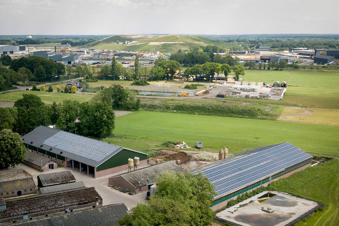 Overzicht van de stallen met de oprukkende industrie op de achtergrond. De afstand tussen stallen en industrieterrein is nu 300 meter.