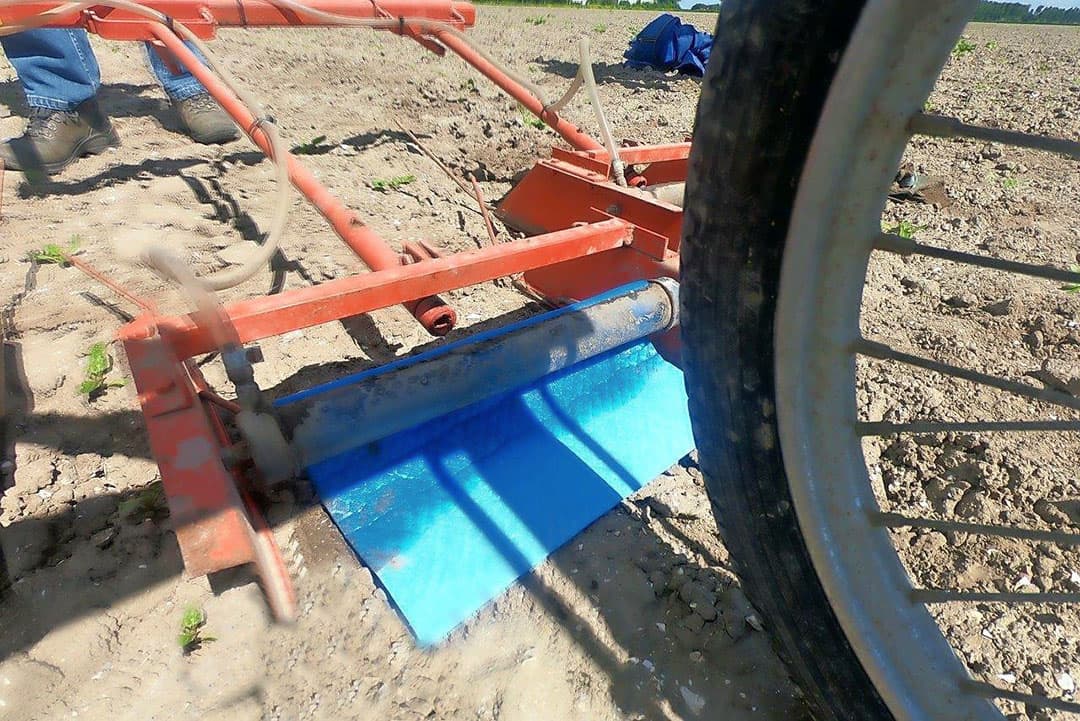 De kappen slepen licht over de grond om de rijen van de paden te isoleren. Met een spleetdop wordt elk pad zo veilig gespoten tegen de opslagplanten.