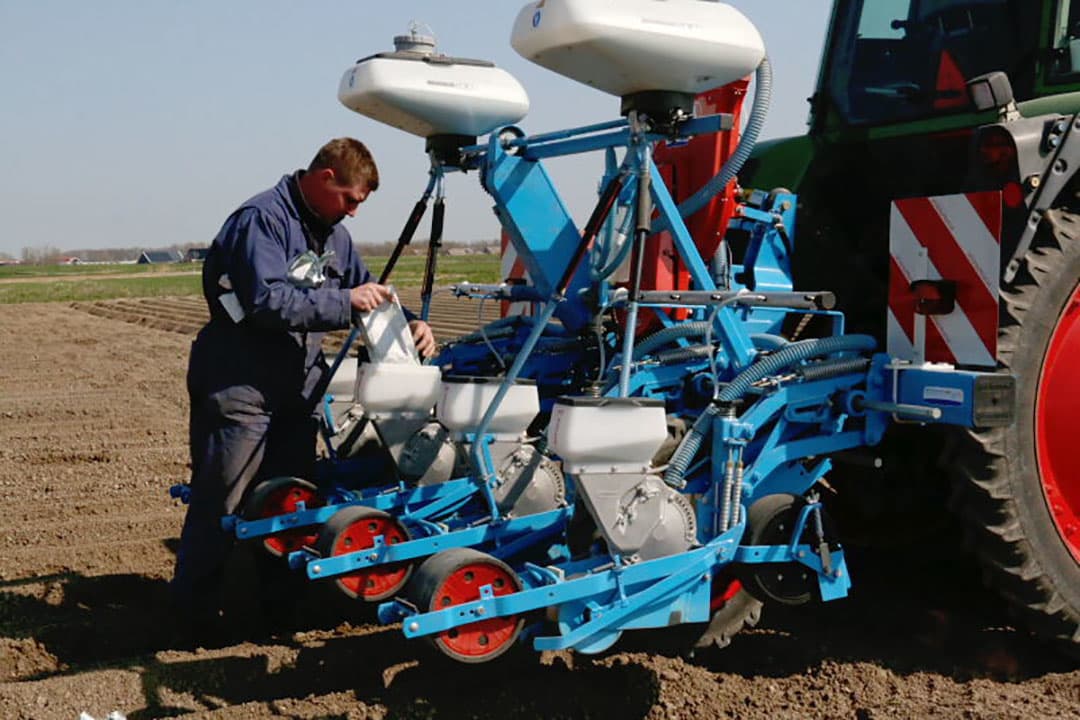 Het pootgoed wordt met een heftruck bij het nabij gelegen bedrijf opgehaald en in de plantbak gekiept.