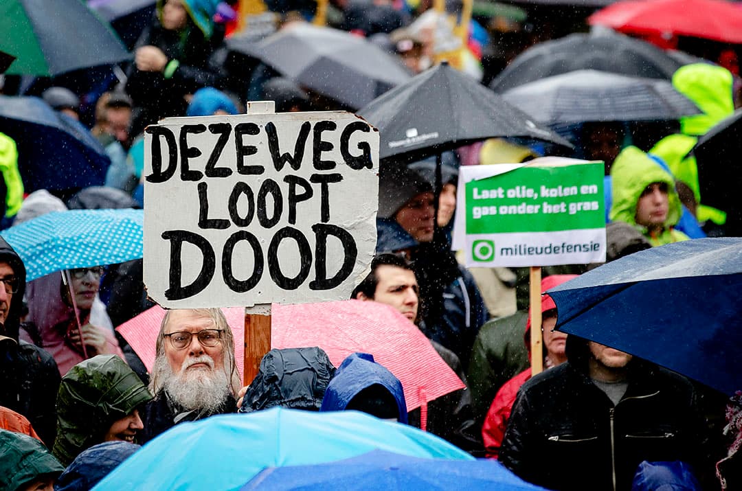 AMSTERDAM - Deelnemers met borden en spandoeken tijdens de klimaatmars. Ze vragen om klimaatactie, door politiek en het bedrijfsleven. ANP ROBIN VAN LONKHUIJSEN