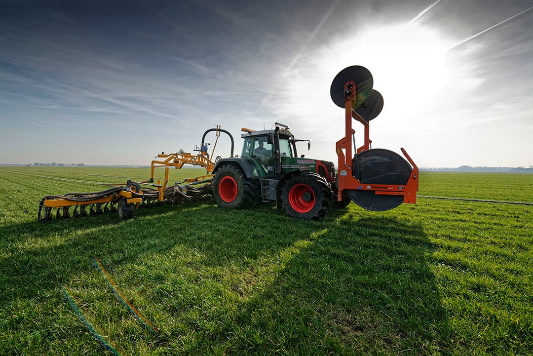 Medewerkers van aspergeteler Paul Custers halen het stro van de aspergebedden af. - Foto: Twan Wiermans