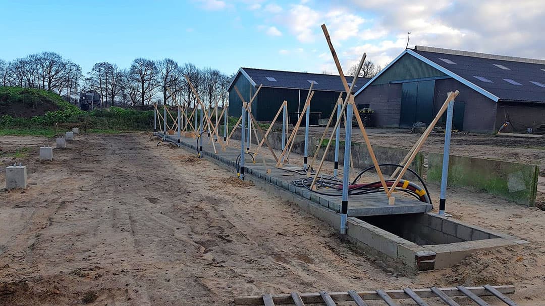 De mestput is aan de voor- en achterkant 1 meter langer dan de stal. Dat is hier duidelijk te zien. Op deze manier kan Smale straks vlot de mest er uitpompen.