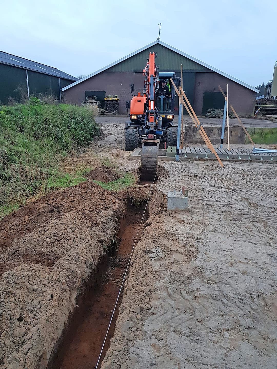 Ook de zijkant is nu klaar. In totaal zijn er 14 oude sleufsilowanden gebruikt. De wand rechts wordt dus geen buitenmuur. Sterker: deze kant van de stal blijft open. De situatie straks van links naar rechts: mestput, strohokken, kalveriglo s. Volgend jaar volgt het volgende deel: beton storten.