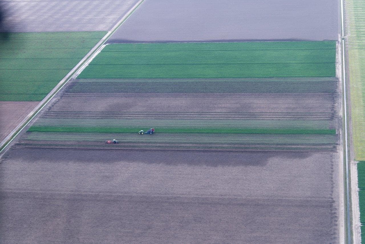 Bollen planten met een John Deere op rups. Het lijkt of dit perceel er bijna in zit.
