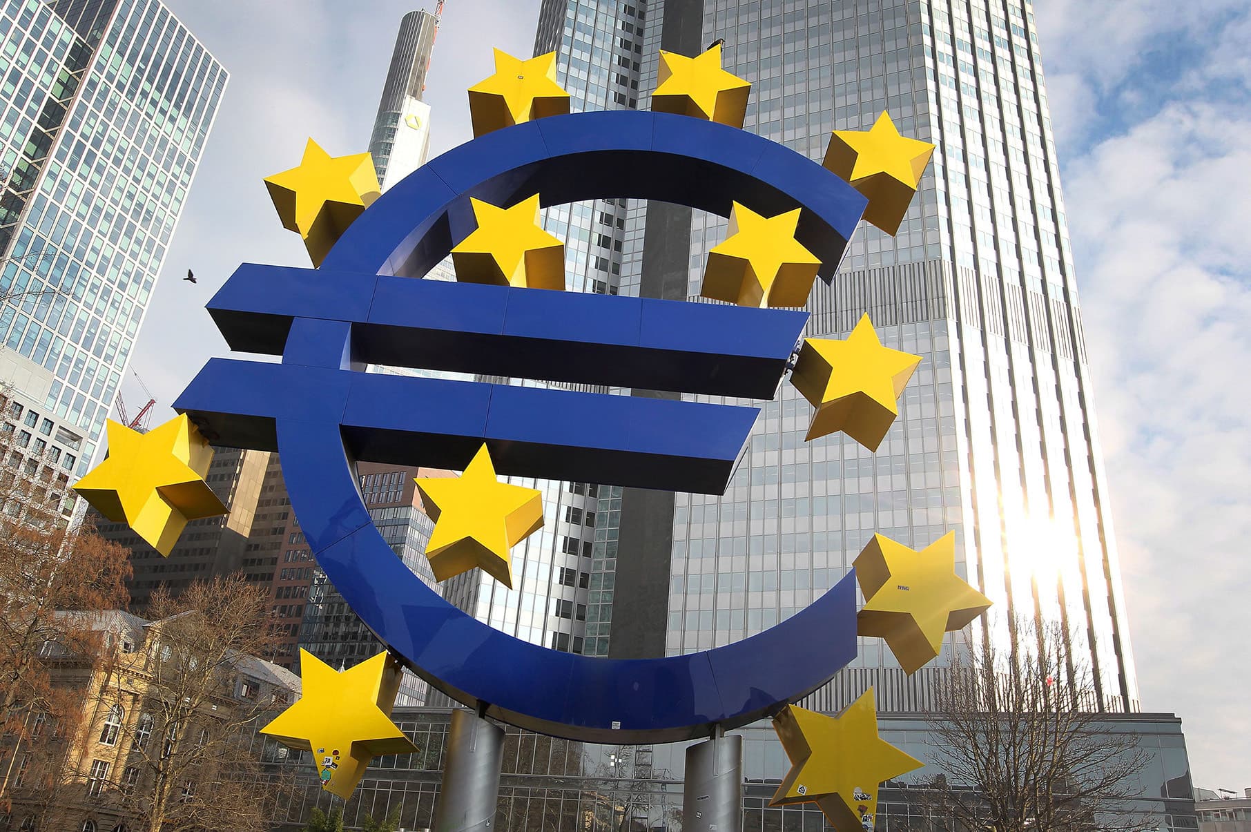 2018-02-07 11:48:53 German artist Ottmar Hoerl's sculpture depicting the Euro logo is pictured in front of the former headquarter of the European Central Bank (ECB) in Frankfurt, western Germany, on February 7, 2018. / AFP PHOTO / Daniel ROLAND