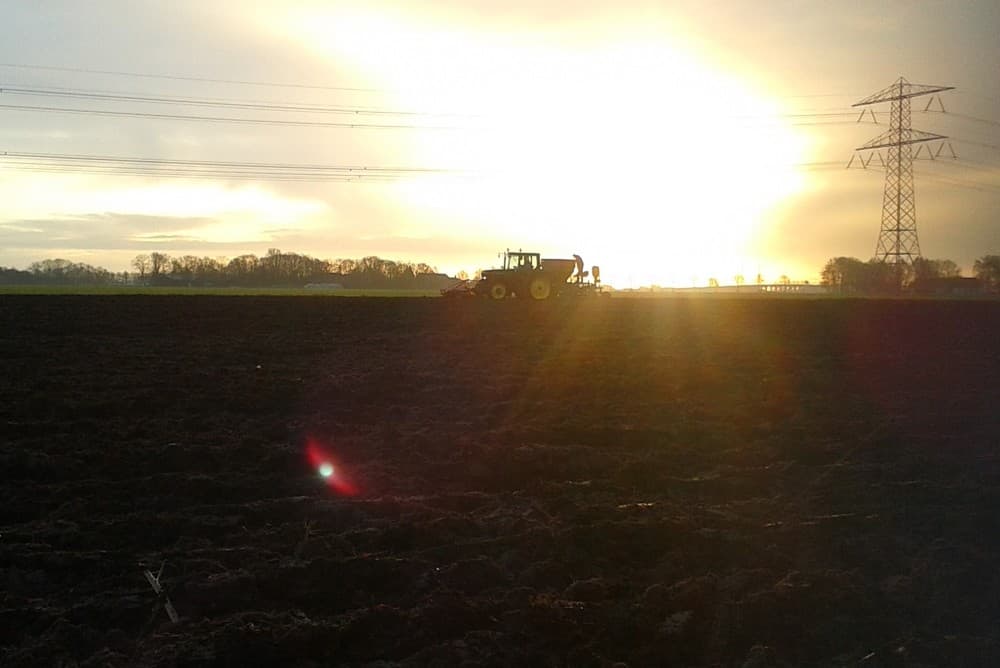 Voor op de trekker wordt de grond voorbewerkt, niet te intensief om slemp of stuiven te voorkomen. De kettingaandrijving tussen de rollen is gedemonteerd.