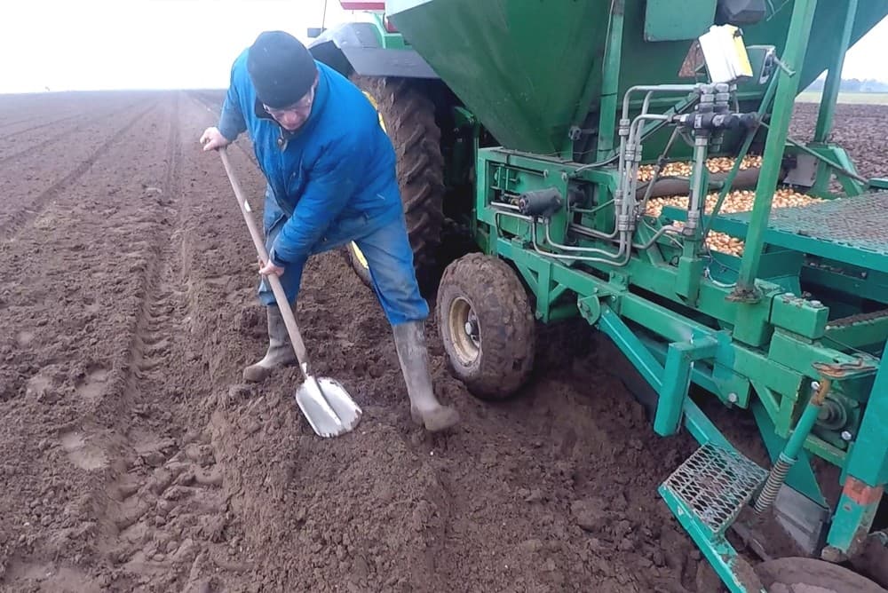De planter met op de trekker André van de Burgwal. Wim van de Burgwal controleert het plantproces.