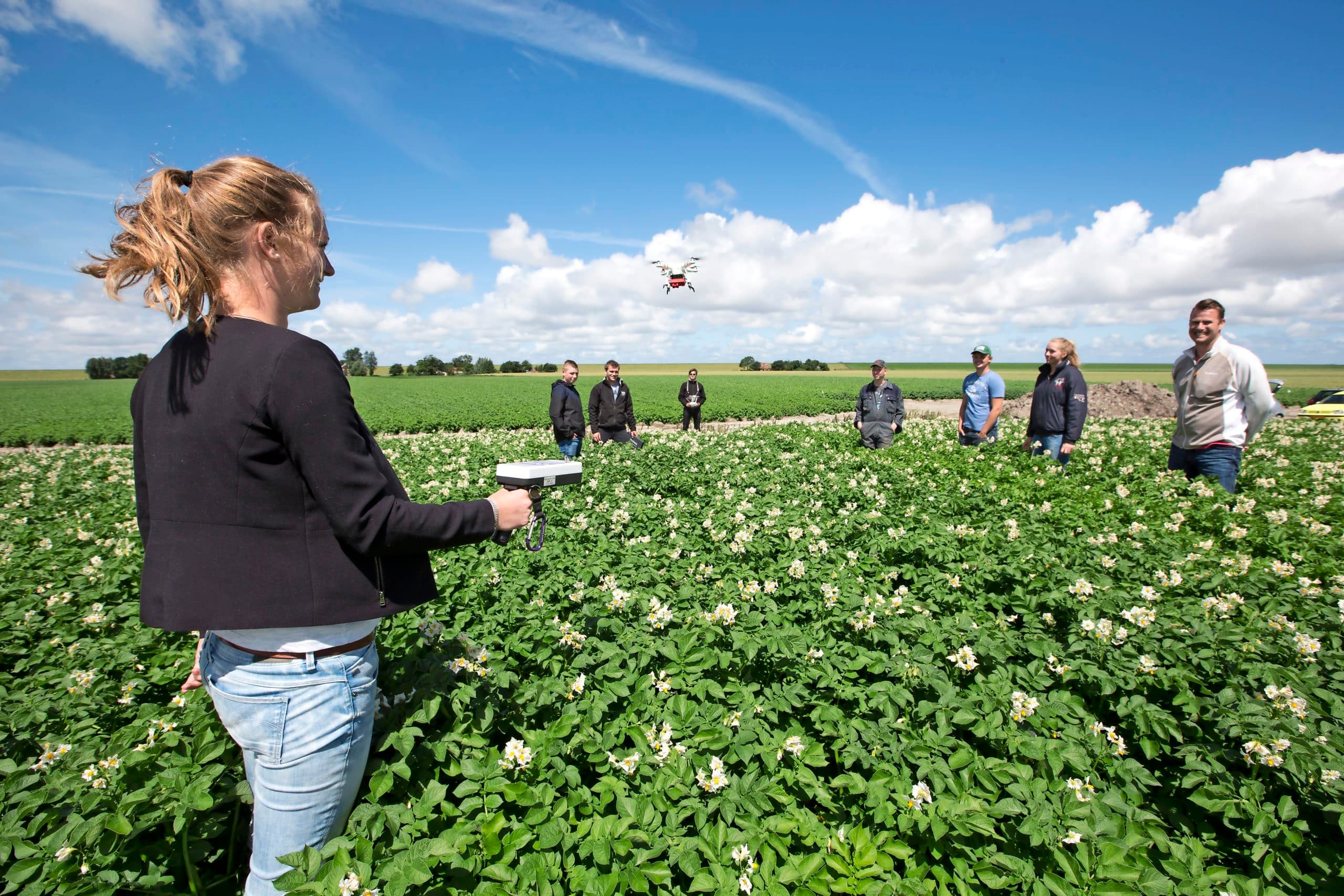 Studenten begeleiden een proef met een precisiebemester waarbij gebruik wordt gemaakt van een drone - Foto: Anne van der Woude