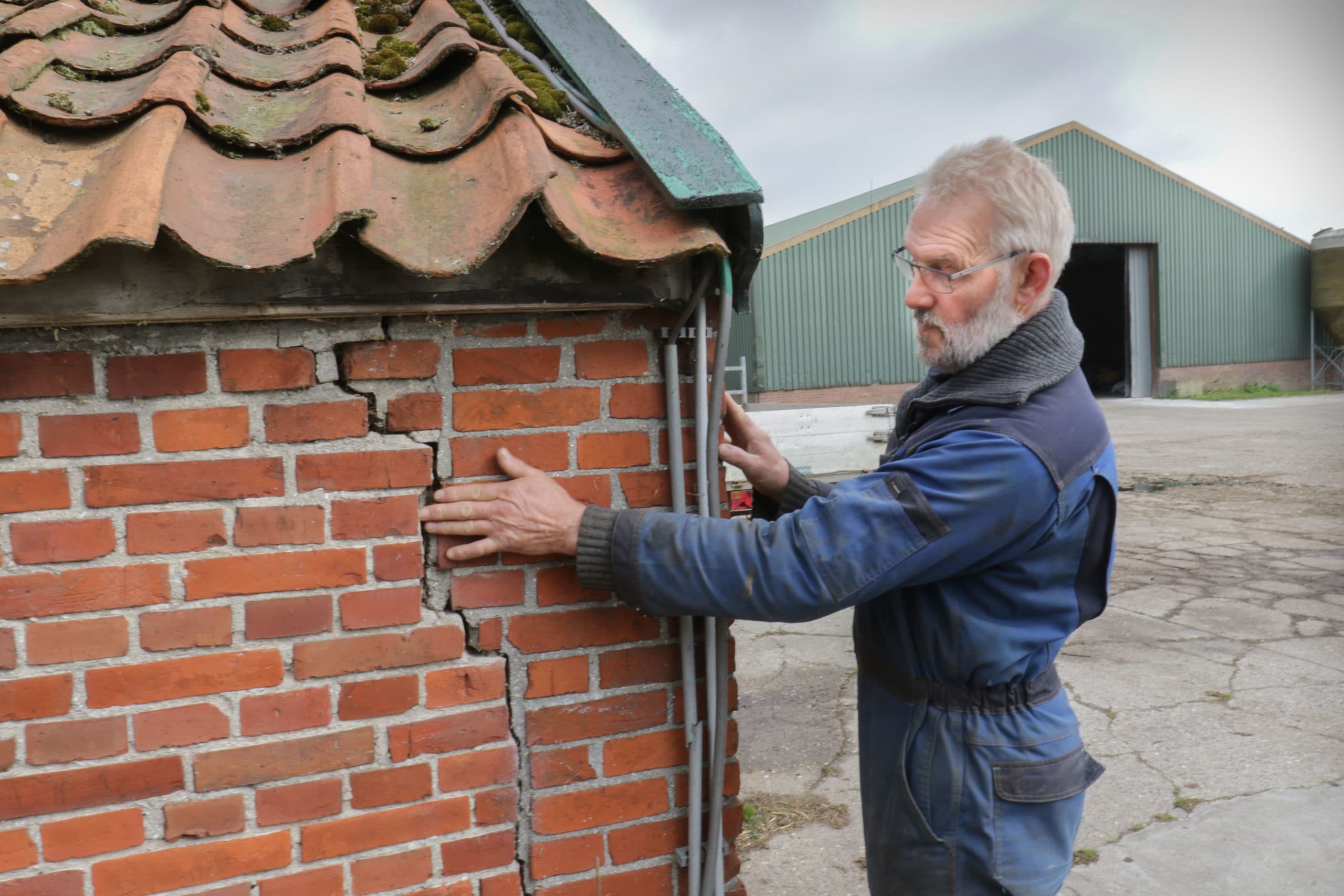 Bé Arkema laat een scheur in de muur van zijn boerderij zien.