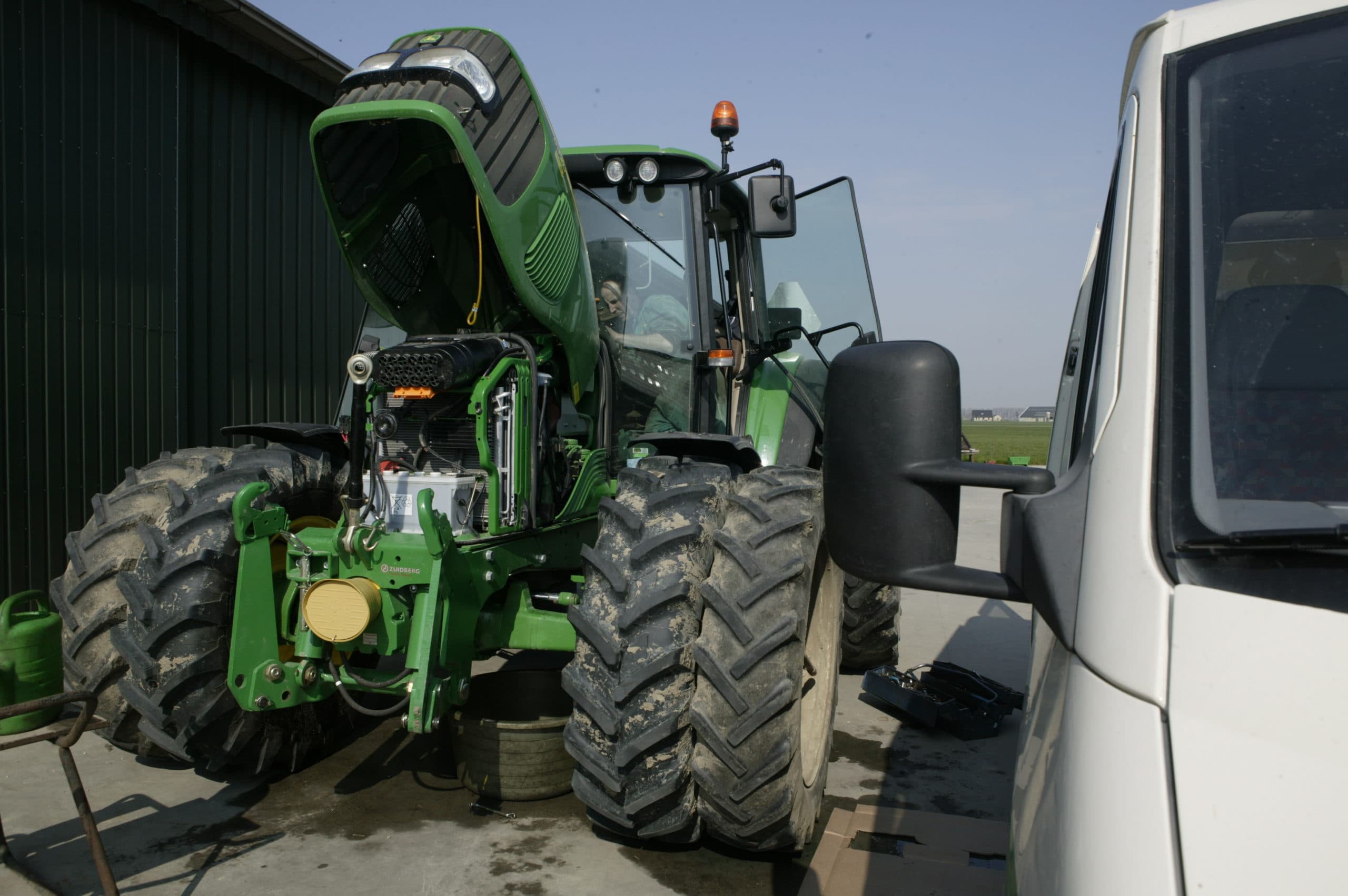 Een John Deere-servicemonteur verhelpt een probleem met de oliekoeler - Foto: Mark Pasveer