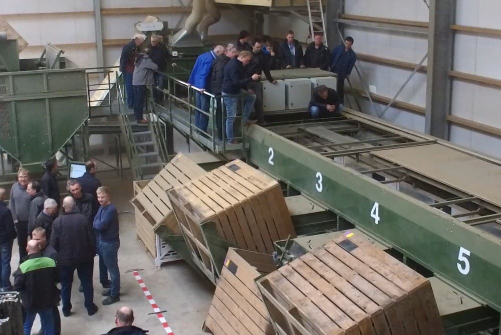 Voor het vullen worden de kisten eerst gekanteld om beschadiging van de aardappelen te voorkomen. Een rood-wit lint waarschuwt niet binnen die lijn te komen.