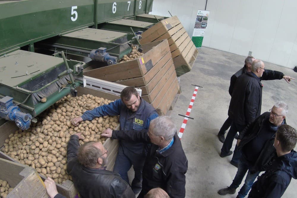 De eerste fase is het netjes op rij leggen en verdelen van het veldgewas over de acht banen. Dat is nodig om iedere aardappel en kluit afzonderlijk te kunnen scannen.