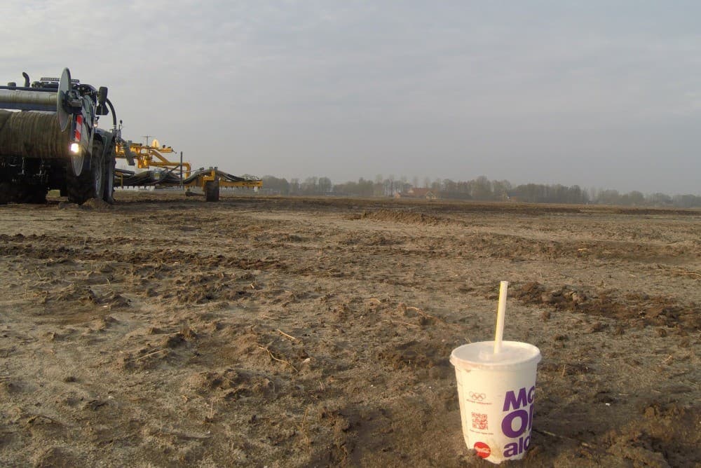 Een simpel koffiebekertje geeft aan tot waar de mest moet worden uitgereden. De bedoeling was om dezelfde dag ook op kleigrond mest uit te rijden, maar een buitje maakte de grond te nat.