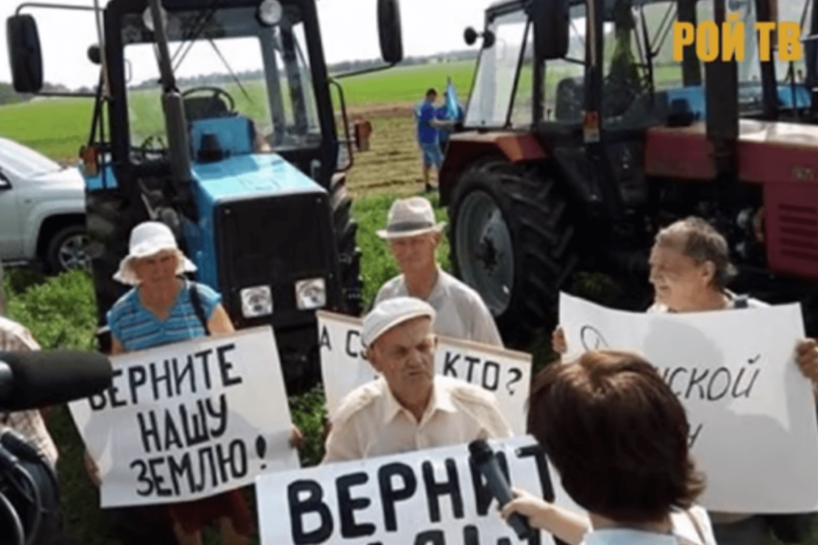 Boeren protesteren met spandoeken: "Geef onze grond terug". Foto: Pon TB