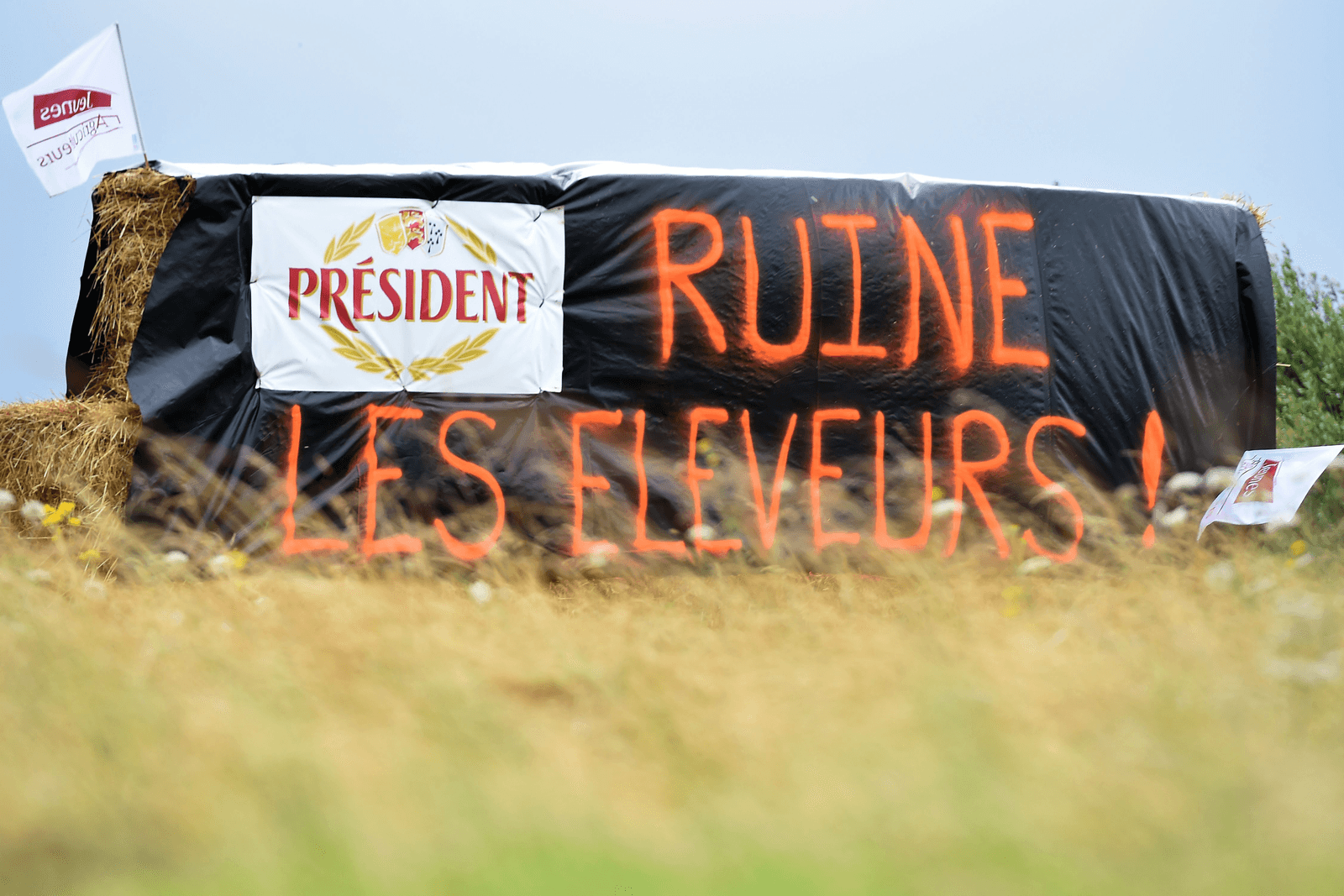 Op de strobalen staat 'Président ruïneert fokkers', uit protest tegen de lage melkprijzen - Foto: AFP