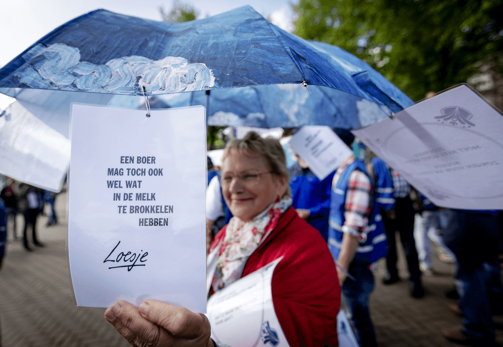 Een actievoerende melkveehouder. Op het papier staat: 'een boer mag toch ook wel wat in de melk te brokkelen hebben'.
