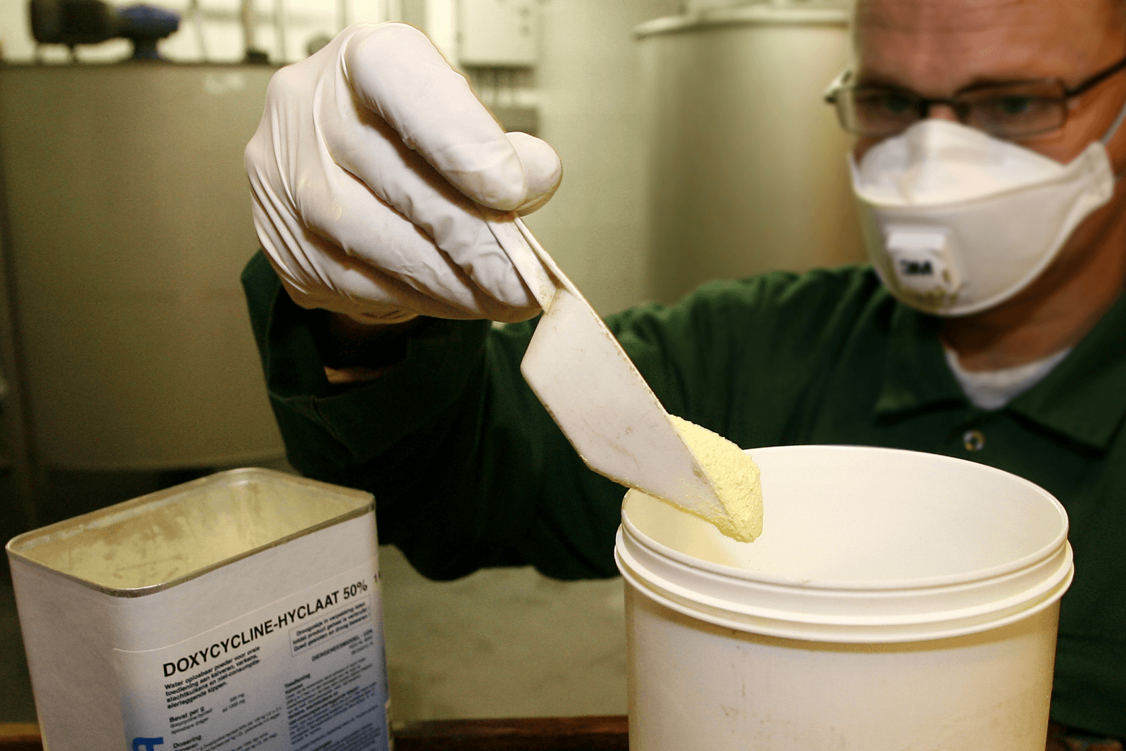 Een medewerker voegt antibiotica toe aan kalvervoer. Het gebruik van antibiotica is teruggedrongen, maar kan nog verder worden beperkt. <br /><em>Foto: Ronald Hissink</em>