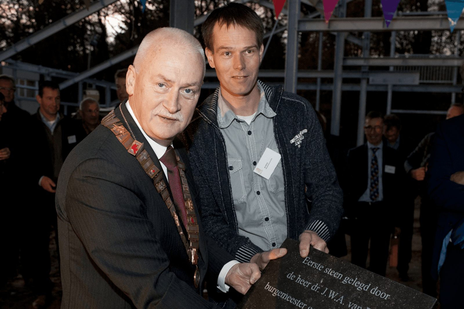 Burgemeester Asje van Dijk (links) van gemeente Barneveld legt de eerste steen. Rechts de ontwerper van het gebouw, Jan Brink. Foto: Poultry Expertise Centre