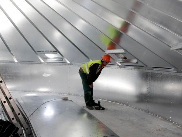 In de silo zitten acht ontluchters. De lucht wordt door de ventilator door het graan geblazen en kan via de ontluchters in het dak ontsnappen.  <br>