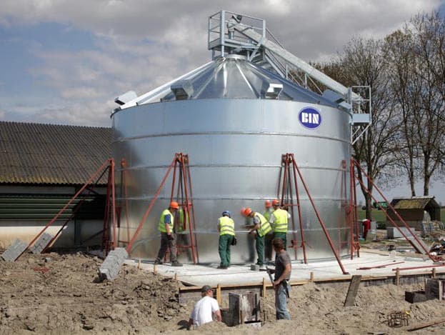De flexibele vijzel komt via deze buis binnen en loopt onder de vloer door naar het midden van de silo.