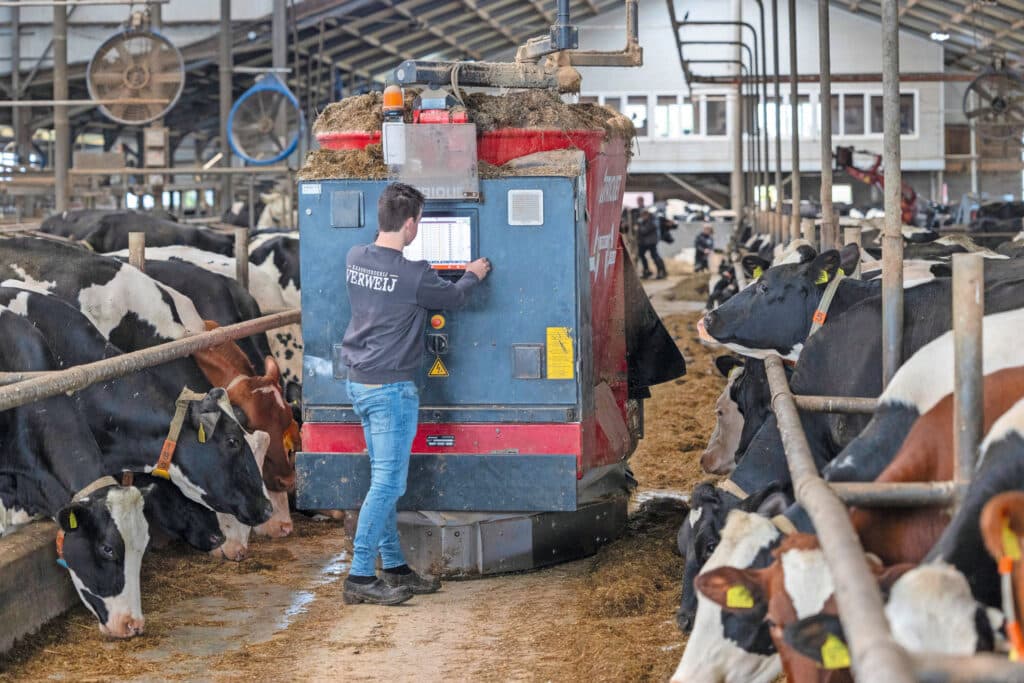 Een voerrobot brengt ruwvoer voor de koeien. Het rantsoen samenstellen doet Corjan met hulp van een voeradviseur.