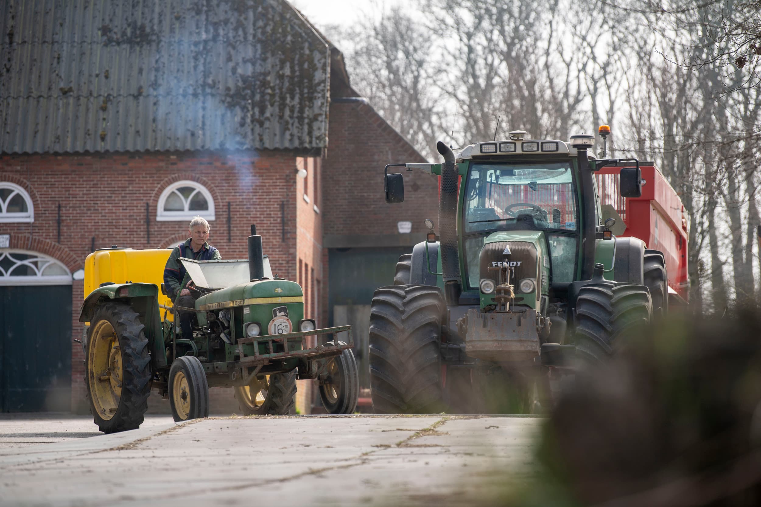 Pluimveehouder Lammert Westerhuis bij zijn bedrijf. Voor het ontsmetten van de stallen gebruikt hij een John Deere 39 uit 1975. Het artikel over zijn bedrijf behoort tot de vijf meest gelezen pluimveeartikelen van 2025. Foto: Mark Pasveer