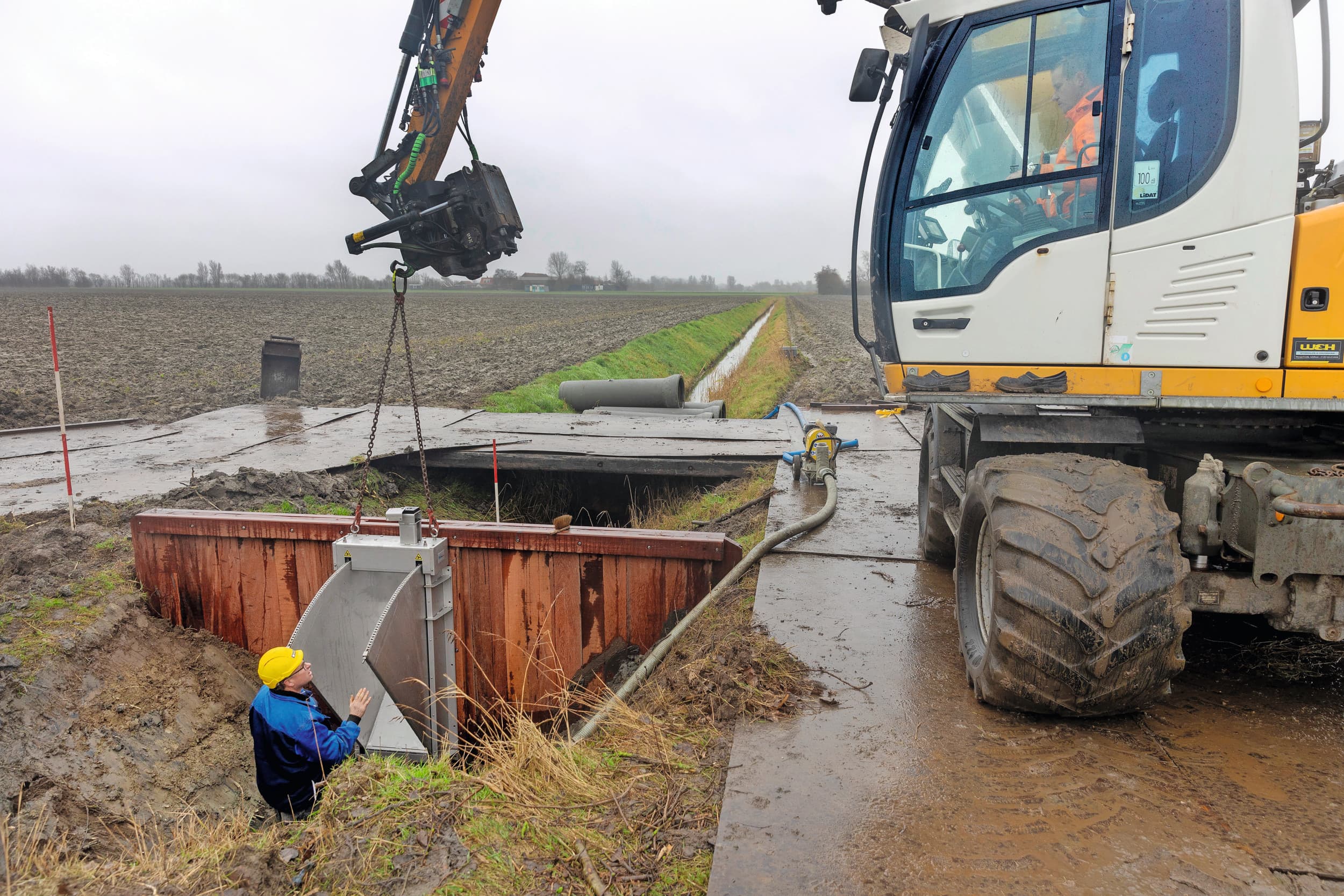 Het plaatsen van een stuw. Veel veehouders hebben al stuwen in sloten langs hun percelen geplaatst. Dit is een eerste stap in het langer vasthouden van water. Foto: Peter Roek