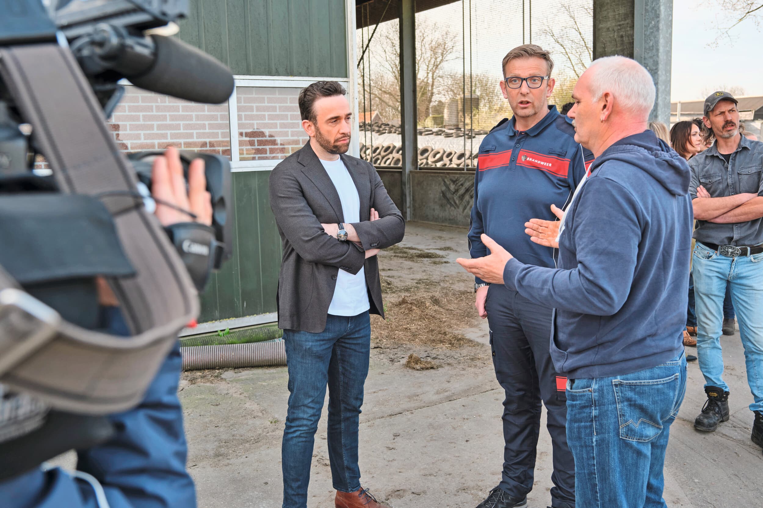 Staatssecretaris Silvio Erkens (l) en Ellard Roersma, hoofd incidentenbestrijding van Brandweer Nederland, luisteren naar melkveehouder Johan Oosthoek, wiens bedrijf vorig jaar werd getroffen door brand in de stal. Foto: Fred Libochant