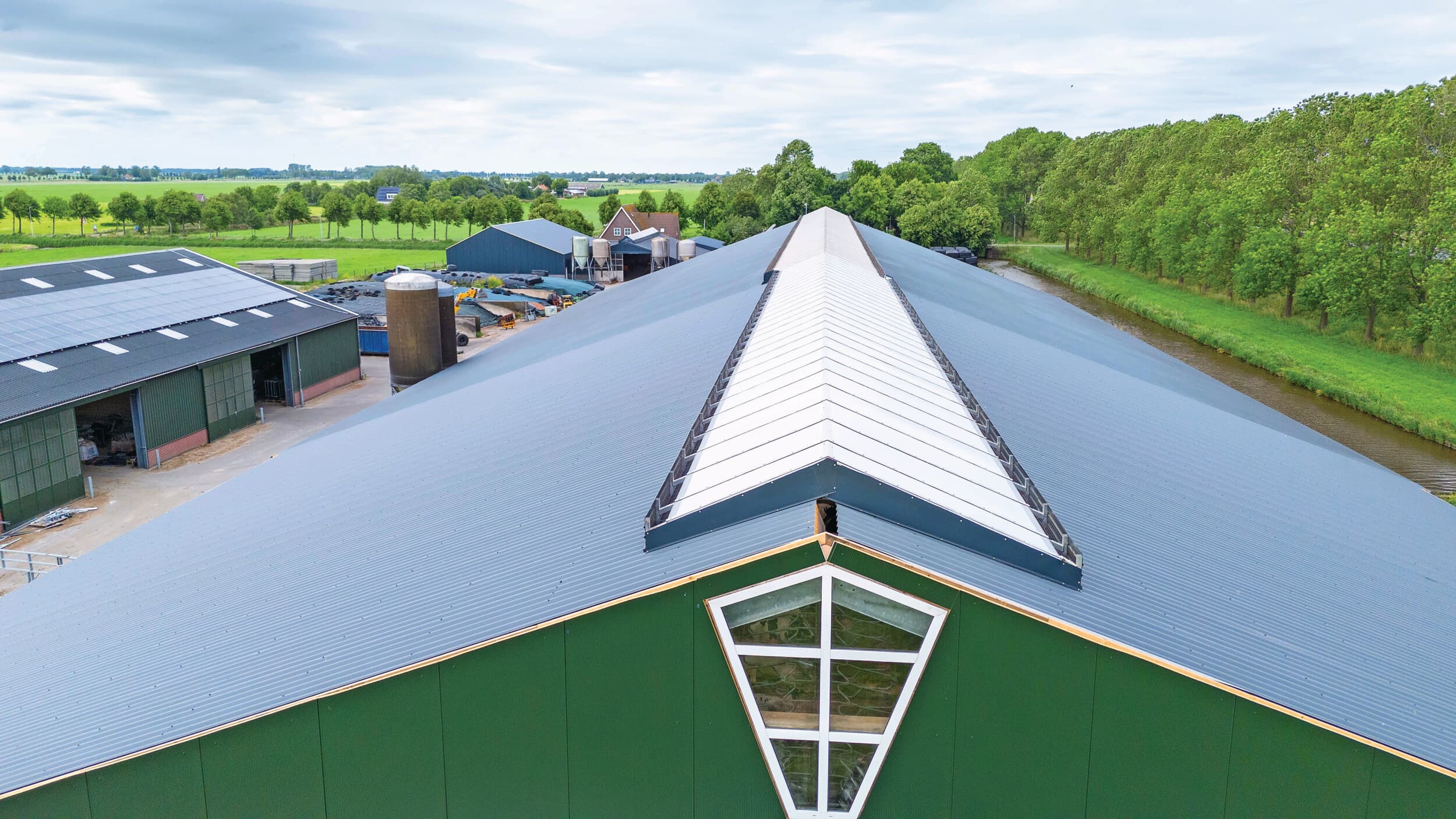 De bestaande stal was uitgevoerd met een dichte nok. Dat vonden de broers, ondanks de open zijgevels, toch te donker in de stal. Om deze reden is nu een lichtnok geplaatst. Ook hier zijn de iets afwijkende afmeting en hellingshoek van de nieuwbouw te zien.