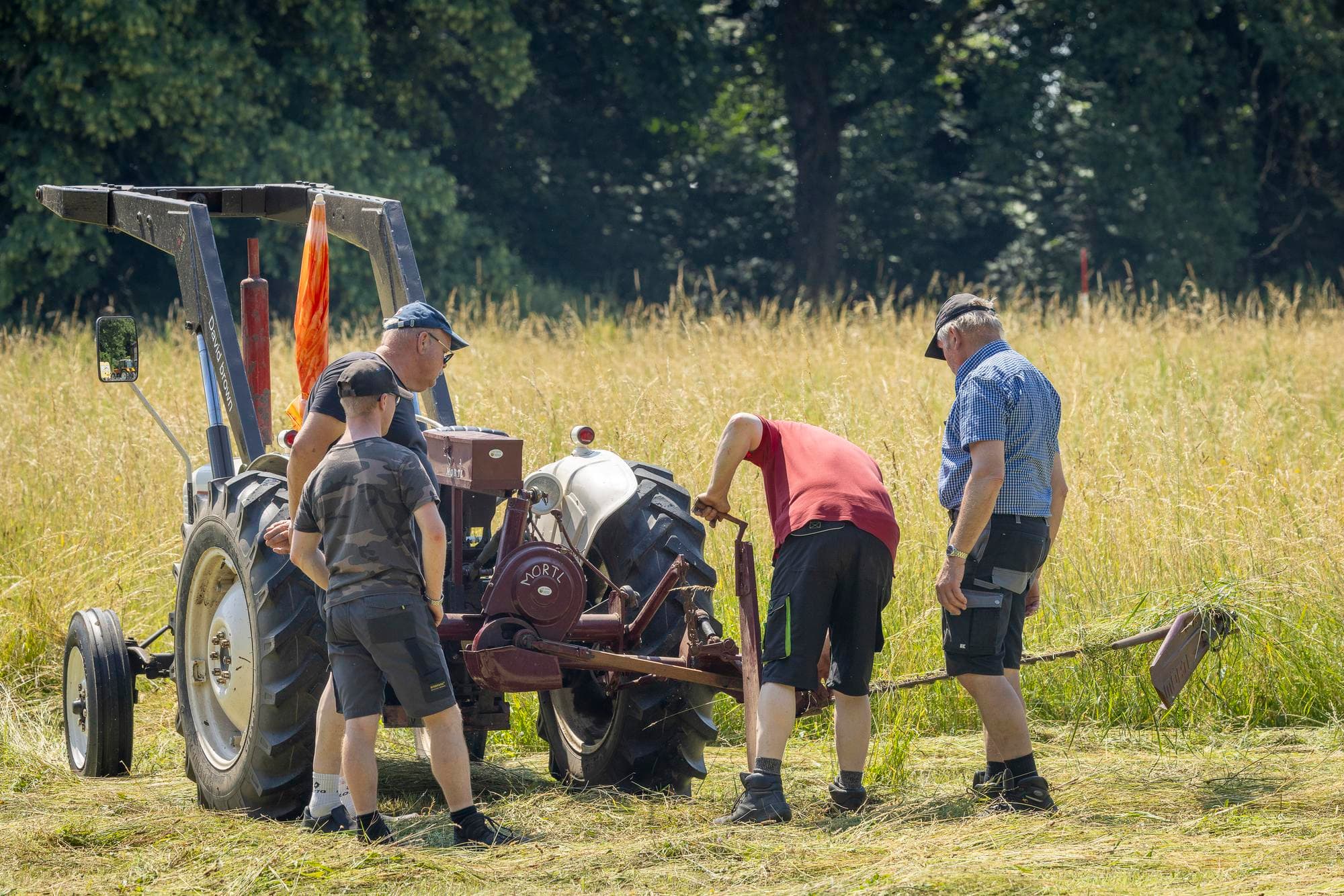 Deelnemers met veel ervaring kijken mee: is de maaibalk goed afgesteld?
