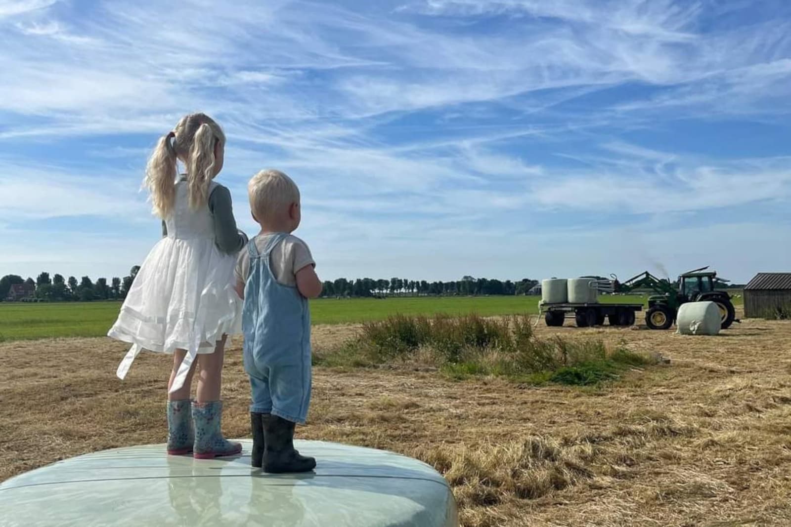 Onder toeziend oog van broer en zus gaan de strobalen van het land. – Foto: Jeffrey Breebaart. Inzending: Anneke de Jong