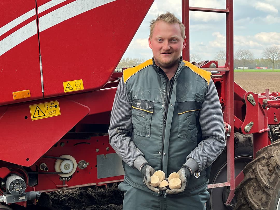 Loonwerker en akkerbouwer Thomas Driessen poot op 20 april voor Ebben Aardappelen gesneden bovenmaat van het fritesaardappelras Première. "Hier op het zand gaat het nu goed", oordeelt hij. Driessen is benieuwd wanneer hij voor Ebben Aardappelen langs de Maas op kleipercelen kan poten. Dat het later in mei wordt, staat voor hem vast. - Foto: Leo Tholhuijsen